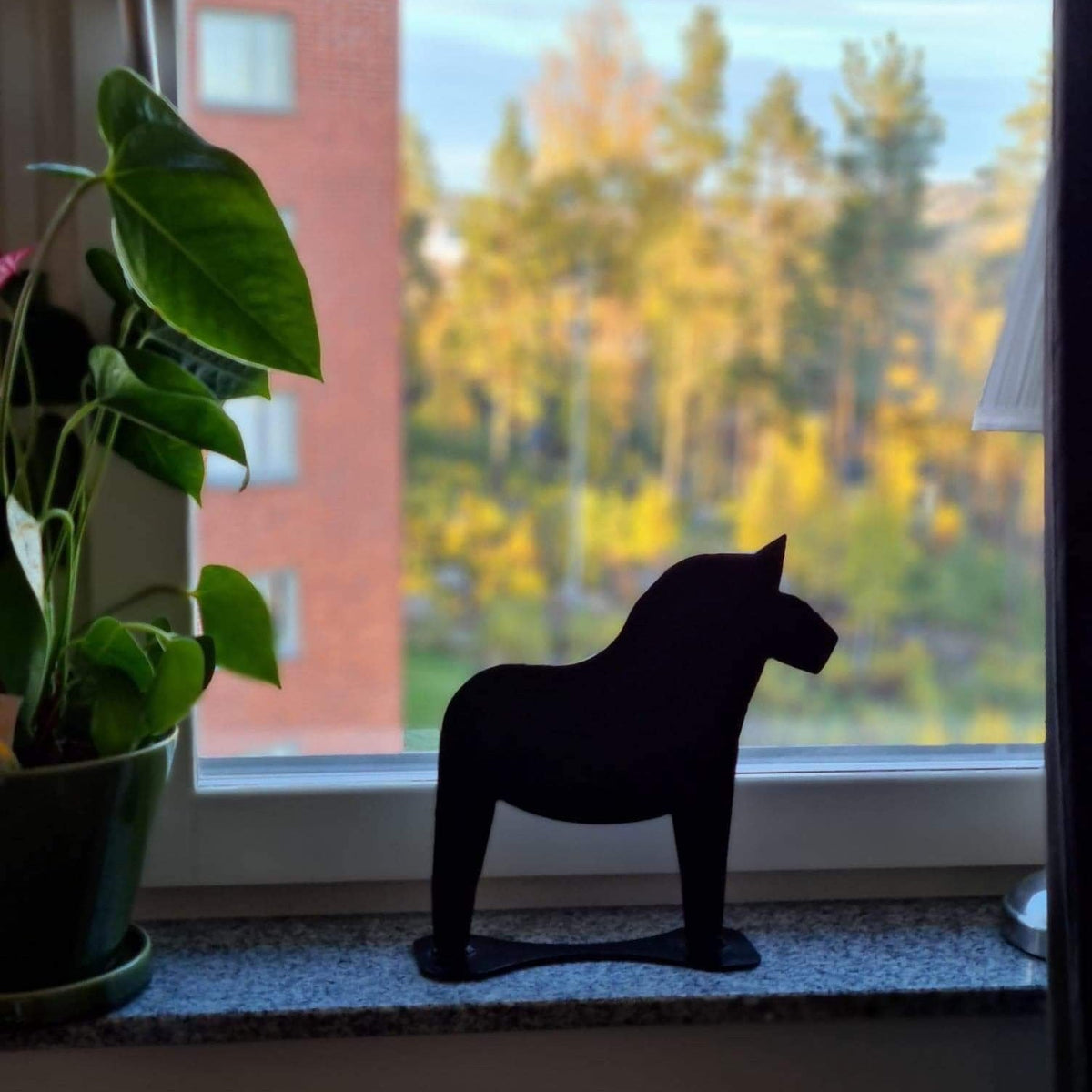 Stående dalahäst svart på fönsterkarm